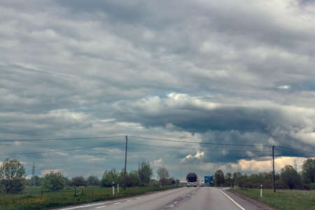 Straight paved road with markings, going into the distance through
