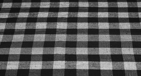 Textile background with checkered tablecloth, top view. Texture of natural linen fabric. selective focus. copyspace. Place for food and drink. Restaurant, menu. Black and white vintage image.の写真素材