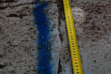 Measuring ruler on a concrete wall texture. The concept of renovation, repair or construction.の写真素材