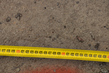Measuring ruler on a concrete wall texture. The concept of renovation, repair or construction.の写真素材