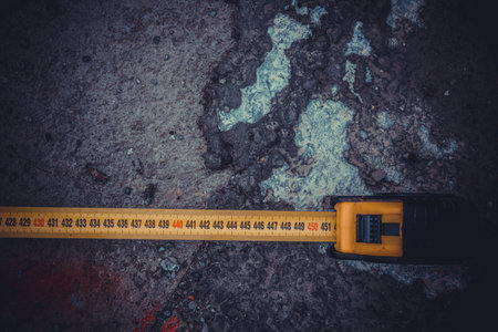 Measuring ruler on a concrete wall texture. The concept of renovation, repair or construction.の写真素材