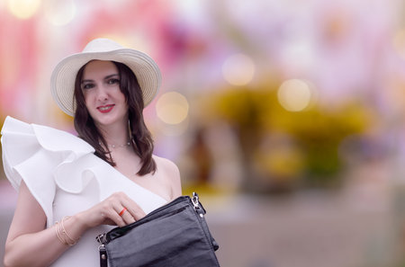 Woman with a handbag in the shopping center. Seasonal sale, womens shopping, light background, woman shopper, buying clothes on black fridayの写真素材