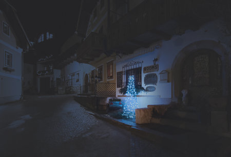 Night scene. A small town with houses lit up for Christmas. Festive season. Hallstatt, Austria. Mountain village in the Austrian Alps during the Advent season.の写真素材