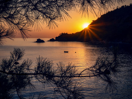 View of calm sea at sunset. Kabak Bay in Fethiye district, Turkey, is located on the Mediterranean Sea at the foot of the Western Taurus. A golden sunset over a calm bay.の写真素材