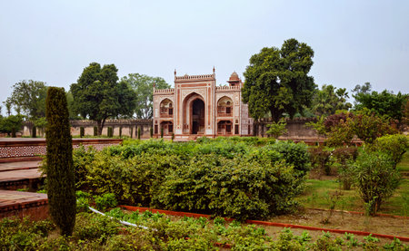 Tomb of Itimad-ud-Daulah or Baby Taj in Agra, India. Paradise Garden. Beautiful garden with a large building in the background. The garden is full of green plants and treesの写真素材