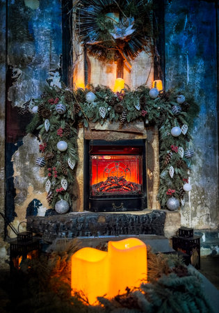 Fireplace with a wreath and candles on it. The fireplace is lit and the candles are lit. Scene is warm and cozyの写真素材
