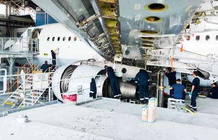 This airplane is disassembled to basic parts and workers and engineers are performing repairs,...