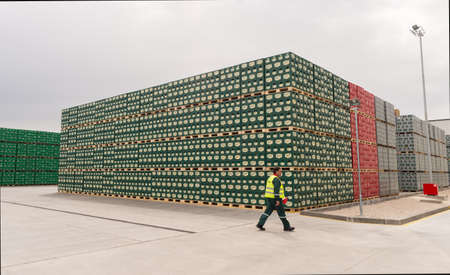 A worker is passing by packs with bottles Staropramen beer are seen in the Molson Coors Kamenitza brewery storage lot, April 28, 2015, near the city of Haskovo, Bulgaria. Kamenitza brewery has been founded in 1881, and Molson Coors Brewing Company bought のeditorial素材