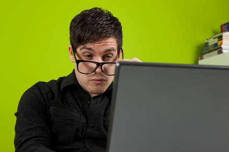 Young man squinting at the laptopの写真素材