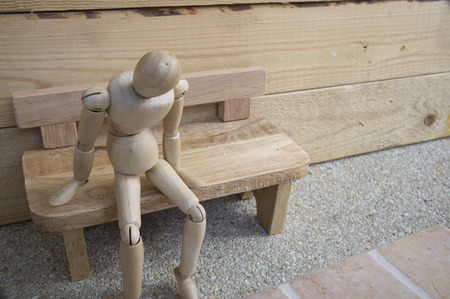 dummy wood man alone on wooden benchの写真素材