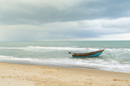 small boat alone ocean beachfront morning  storm dangerの写真素材