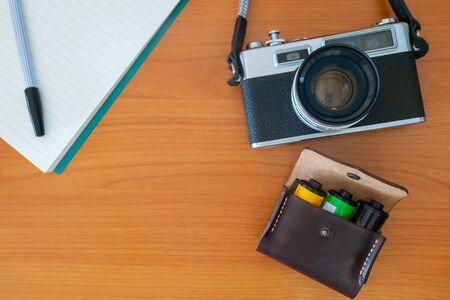 Old Vintage Film Camera and Notebook and Leather Bag of Camera Films Preparing for Travelの写真素材