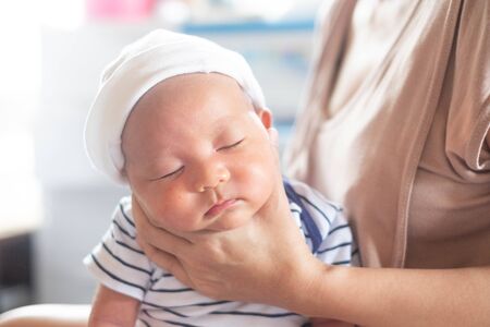 Soft focus photo of mother, mom using hand Hold baby to help a baby newborn infant belch burping...