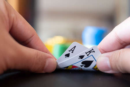 The Casino table with cards showing black jack on hand and blurred casino chips and Gold coin  in...