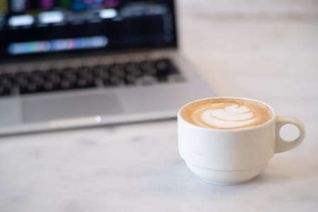 Close-up of Hot coffee latte with latte art milk foam in cup or mug on desk in coffee shop at the cafe business work conceptの写真素材