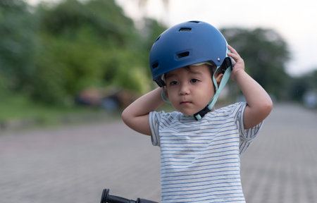 Little kid Boy adjusting bike helmetの写真素材