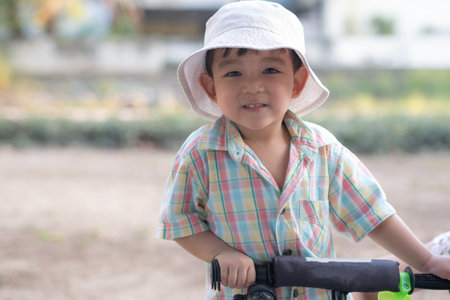 close up portrait of beautiful sweet boy, wearing White bucket hat and colorful shirt, looking at camera, big dark eyesの写真素材