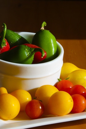 Red and green peppers with yellow and red tomatoesの写真素材