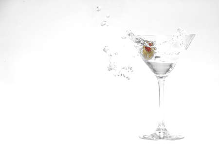olive splashing into a full martini glassの写真素材