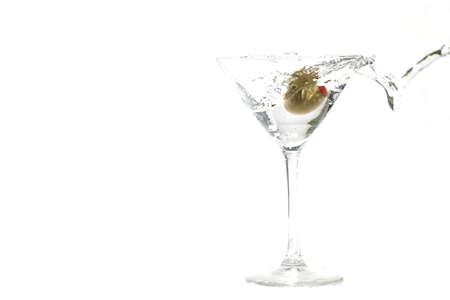 olive splashing into a full martini glassの写真素材