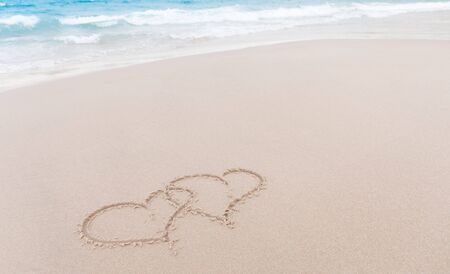 Two hearts drawn in the sand at the beachの写真素材