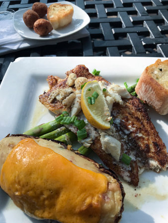 Plated grilled fish dinner with sides.