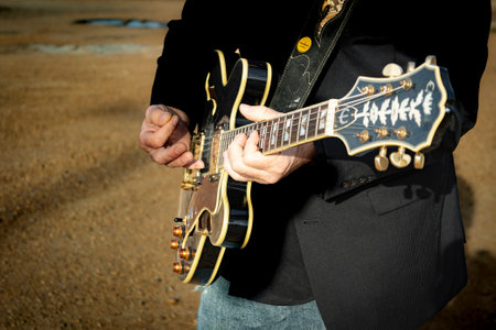 Close up of a musician playing a guitar.