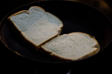 Toasting bread in a pan with butter.の写真素材