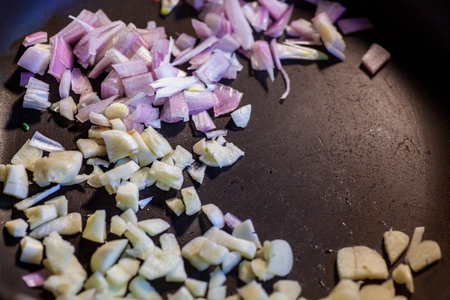 Chopped red onions and garlic in saute pan.の写真素材