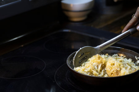 Shredded hash browns cooking in cast iron skilletの写真素材