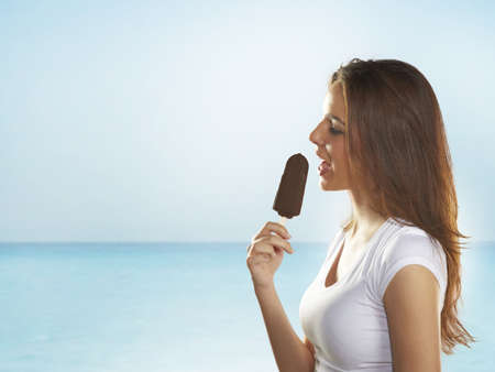 Woman holding a delicious ice cream on the seaの写真素材