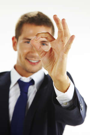 Portrait of handsome young man gesturing okay signの写真素材