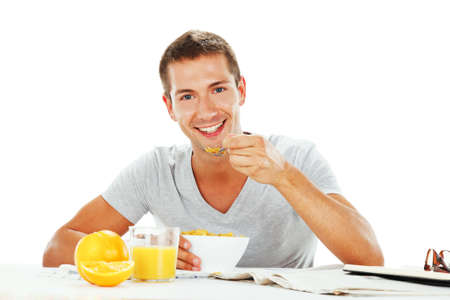 Happy young man having energetic breakfastの写真素材
