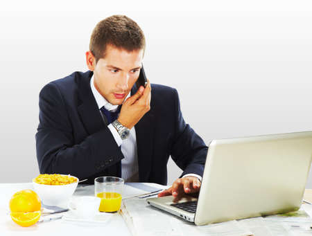 Businessman with laptop and breakfastの写真素材