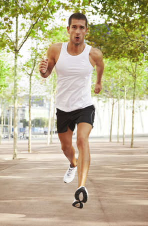 caucasian male athletic jogging outdoor with green trees