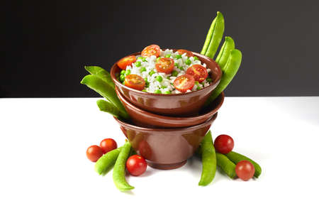 Bowl of rice with tomatoes and peasの写真素材