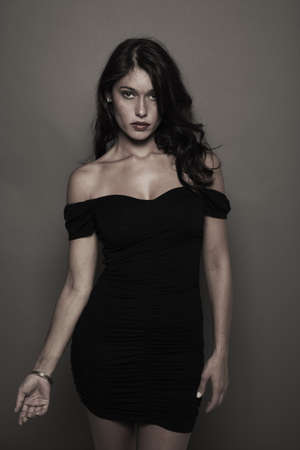 fashion photo with a gray background and a brunette model