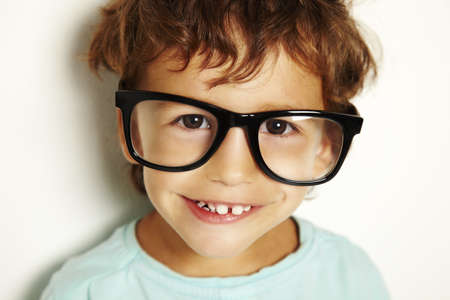 little caucasian boy with black glasses on white background の写真素材