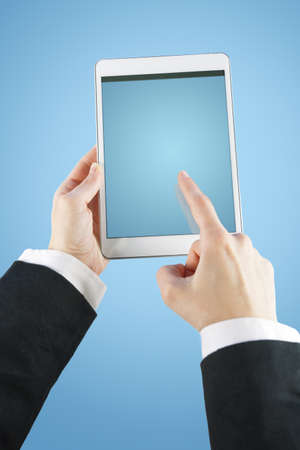 hands touching a tablet on blue background