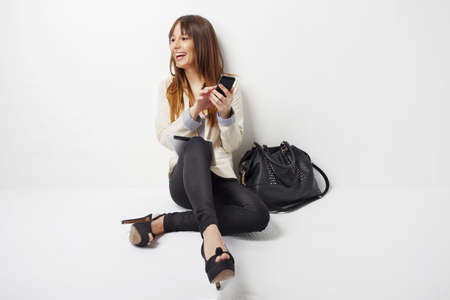 Young business woman with mobile phone isolated on whiteの写真素材