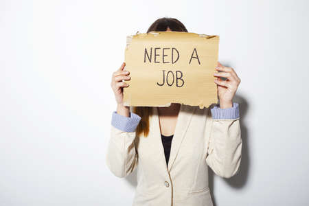 Beautiful business woman showing cardboard with a messageの写真素材