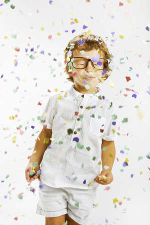 Portrait of a happy child wrapped with confettiの写真素材