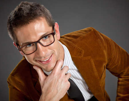 Portrait of attractive businessman on grey backgroundの写真素材