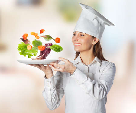 Chef serving empty plate with vegetables in suspensionの写真素材