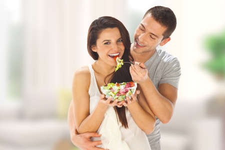 Young couple tasting a saladの写真素材