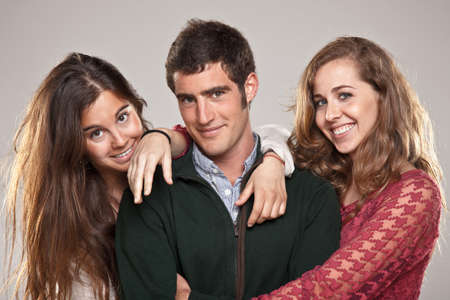 Portrait of three young friends over grey backgroundの写真素材