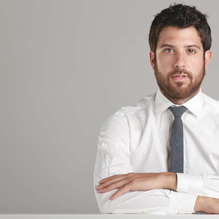 Young man sitting and crossing arms.
