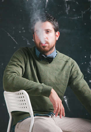 Caucasian man sitting and smoking の写真素材