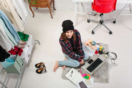 Young creative woman sitting in the floor with laptop の写真素材