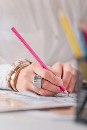 Hands drawing with pink pencil 